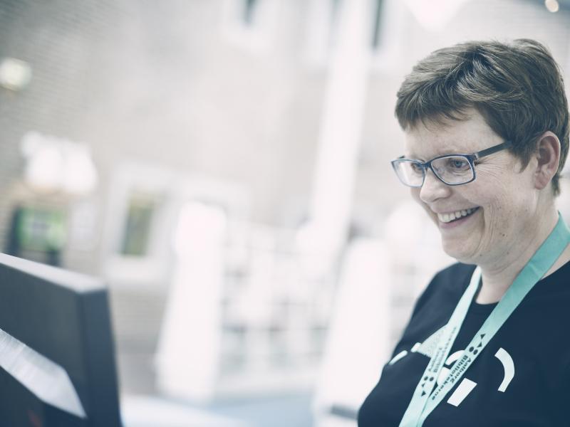 En bibliotekar står og smiler