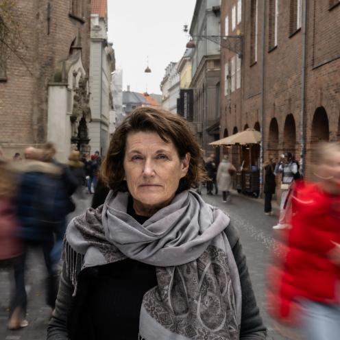 Portræt af Janne Teller. I baggrunden går en masse mennesker forbi.