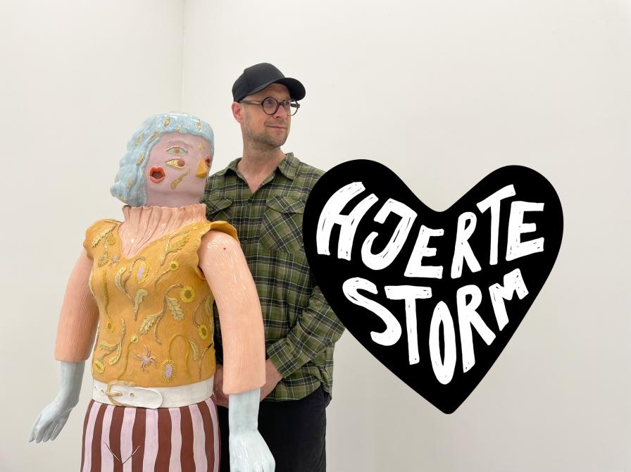 Galleriejer Rasmus Fischer står med et værk, der forestiller en dame hvor ansigtets dele sidder forkerte steder.